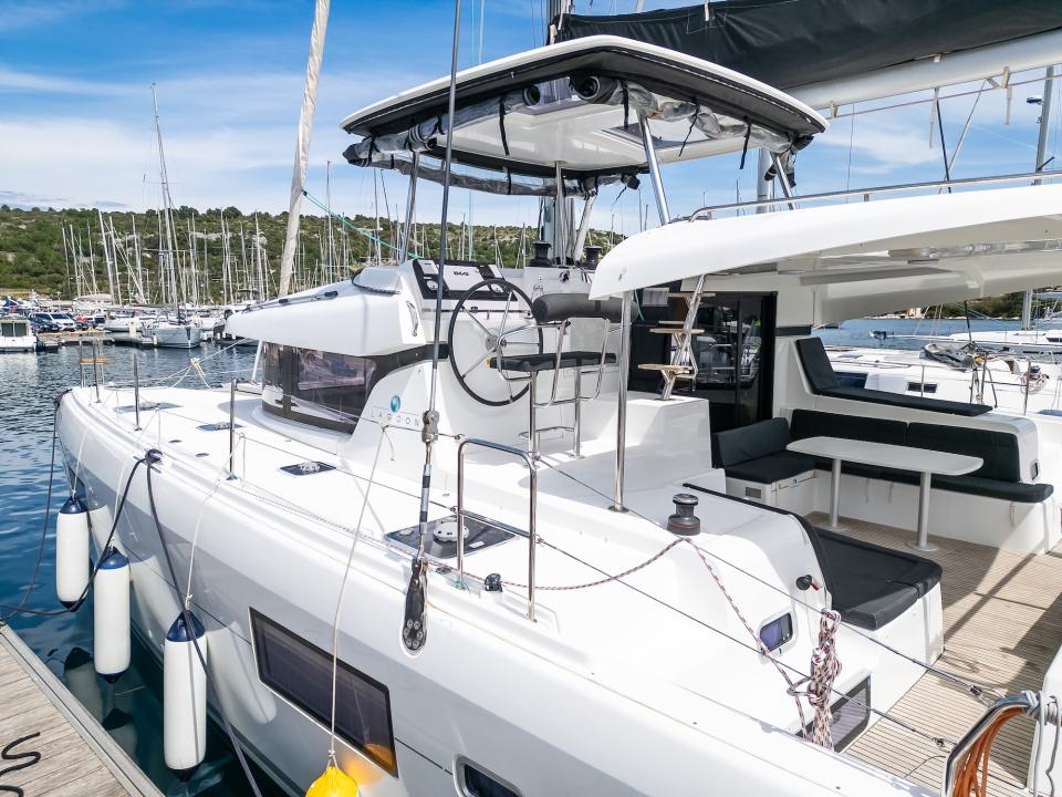 Cockpit with teak floor, table and cushions under the bimini