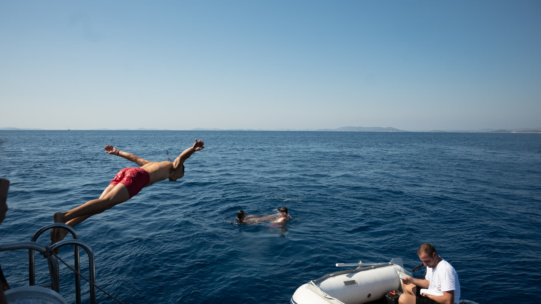 Guests diving off the boat into open water