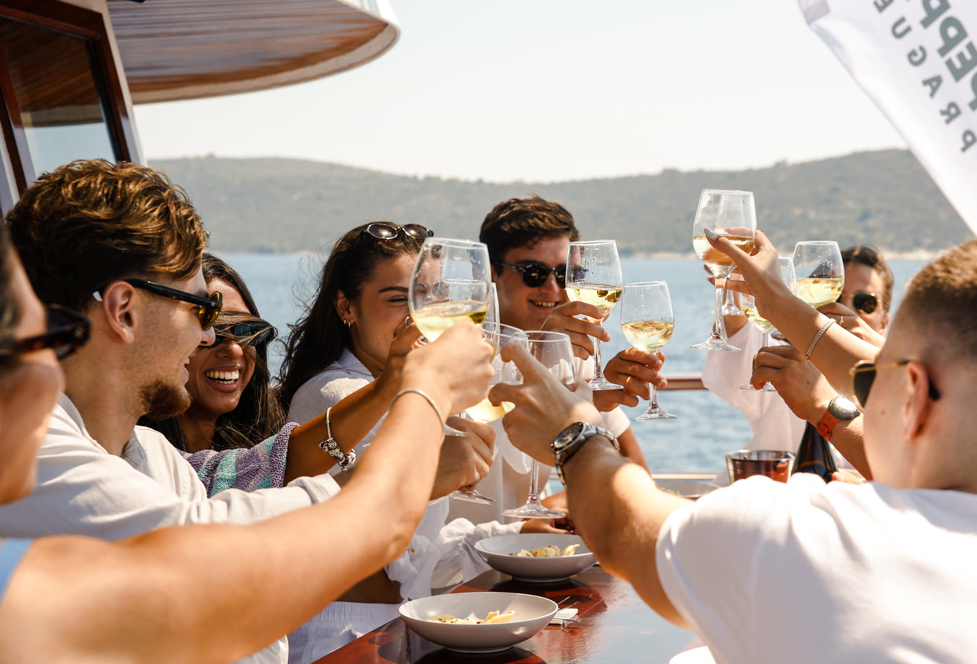 A long table on deck, everybody raising a glass